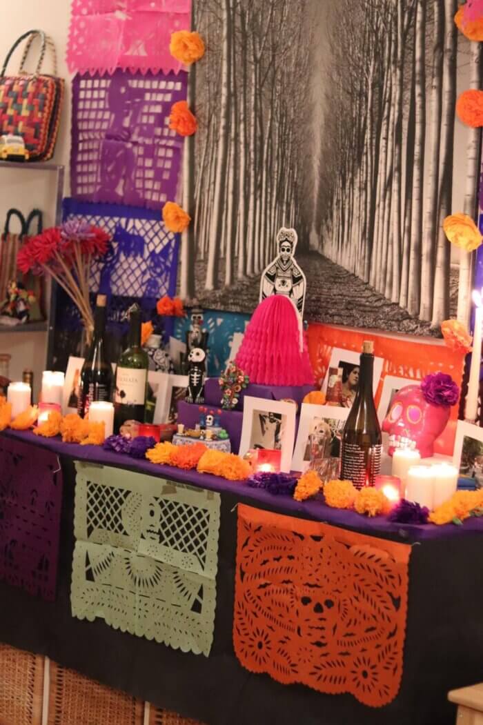 Jak se slaví Día de los Muertos - Oltář s ofrenda k Día de los Muertos s fotkami, catrinou, květinami a občerstvením. 