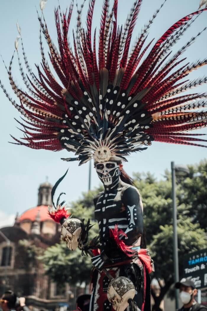 Aztécký tanečník v tradičním kostýmu během Día de Muertos v Mexico City na náměstí Zocalo.