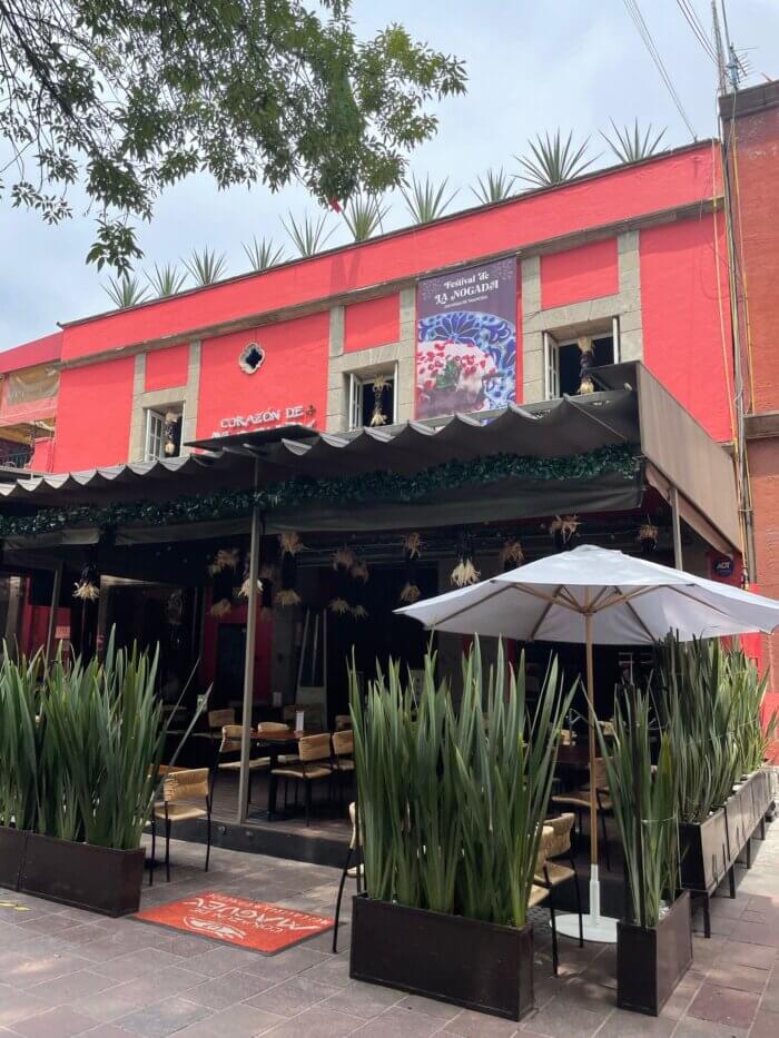 Restaurace Corazón de Maguey v Coyoacánu v Mexico City s venkovní zahrádkou a slunečníky.