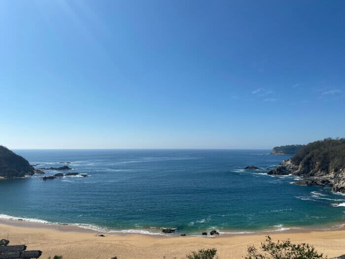 Co dělat v Mexiku: Zátoka v Huatulcu obklopená skalami a zelení s tyrkysovou vodou Tichého oceánu.