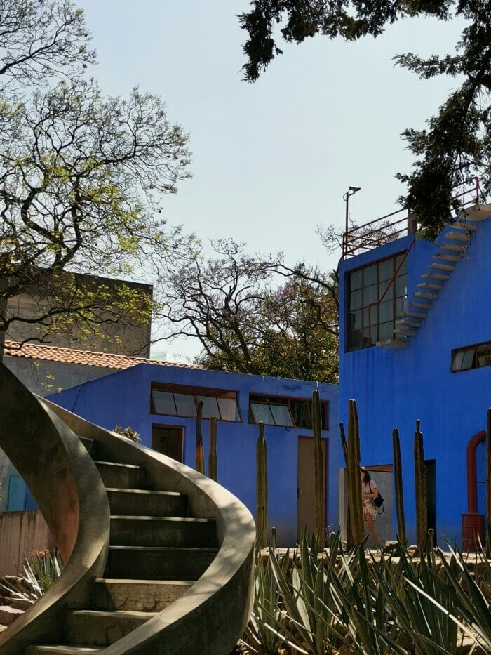 Pohled na nádvoří muzea Casa Estudio Frida Kahlo a Diego Rivera v San Ángel v Mexico City, obklopené modernistickou architekturou a kaktusy.