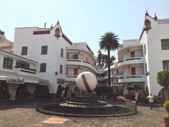 Pasaje Polanco v Mexico City, koloniální budovy s bílými fasádami, palmou a kavárnami v přízemí.