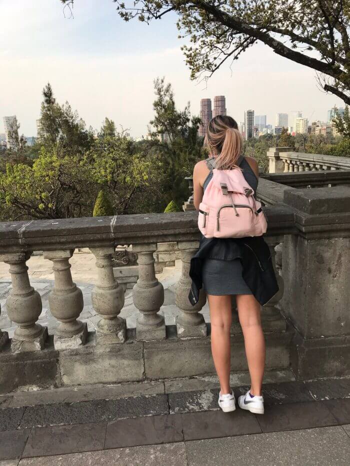 Cestovatelka s růžovým batohem obdivuje výhled na čtvrť Polanco z terasy Castillo de Chapultepec v Mexico City.