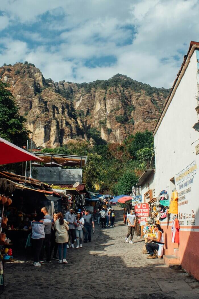 Co vidět v Mexiku? Kamenná ulice ve vesnici Tepoztlán s výhledem na hory a pyramidou El Tepozteco v Mexiku.