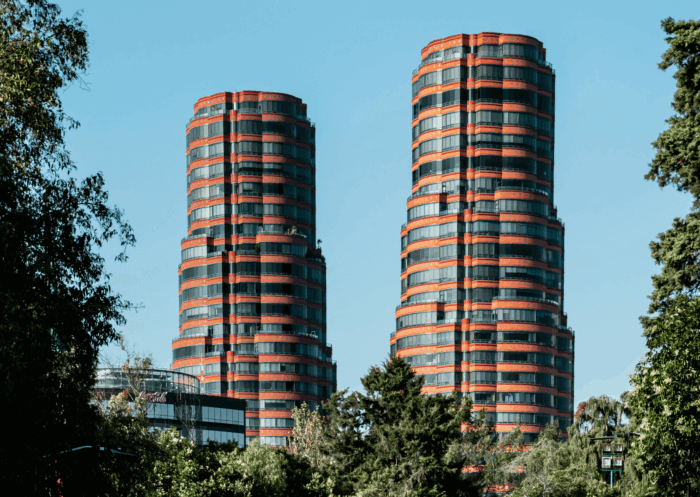 Torres Coca-Cola v Polancu, dvojice moderních červených kruhových budov v Mexico City s modrou oblohou v pozadí.